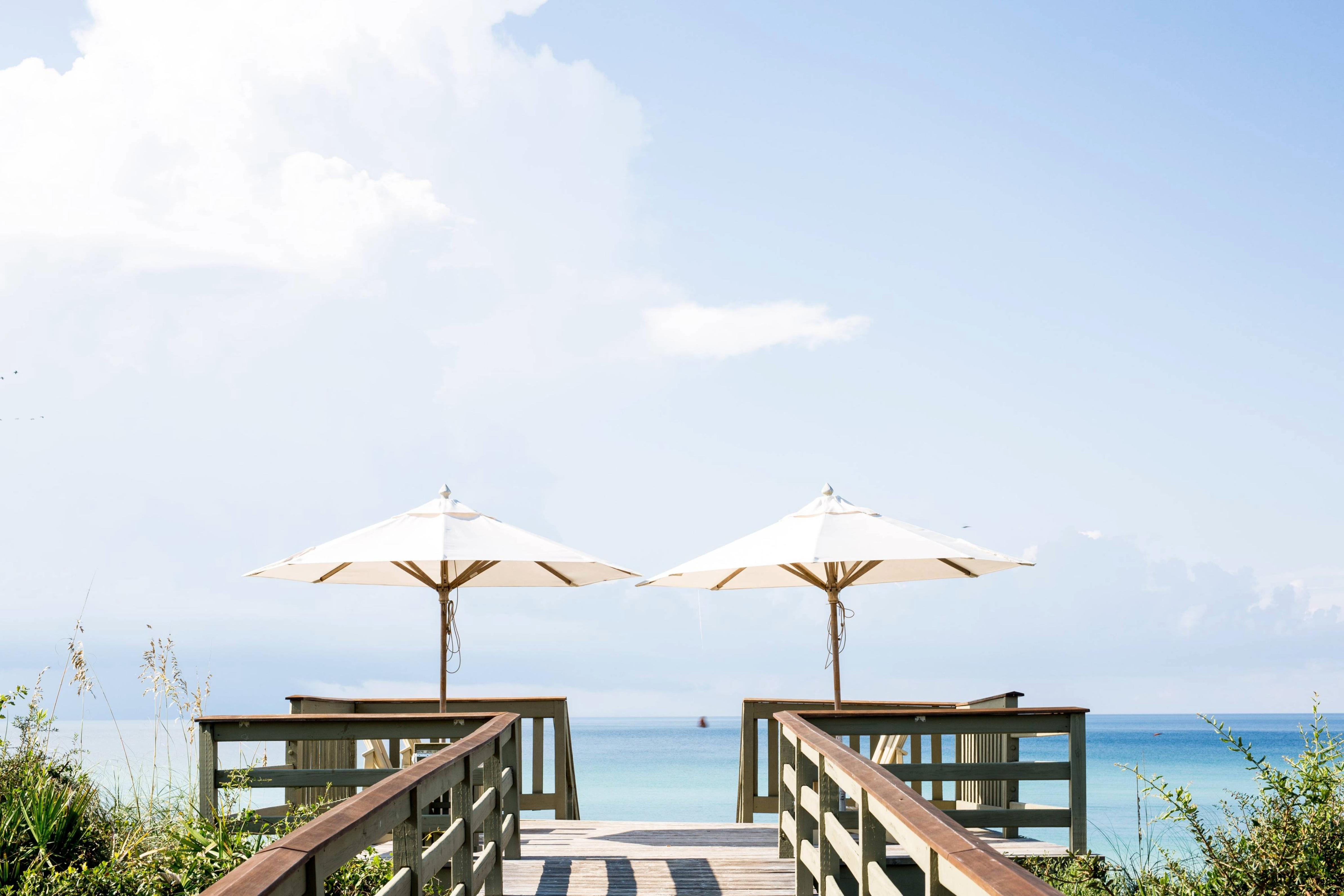 Rustgevende achtergrondfoto met twee parasols en de zee.